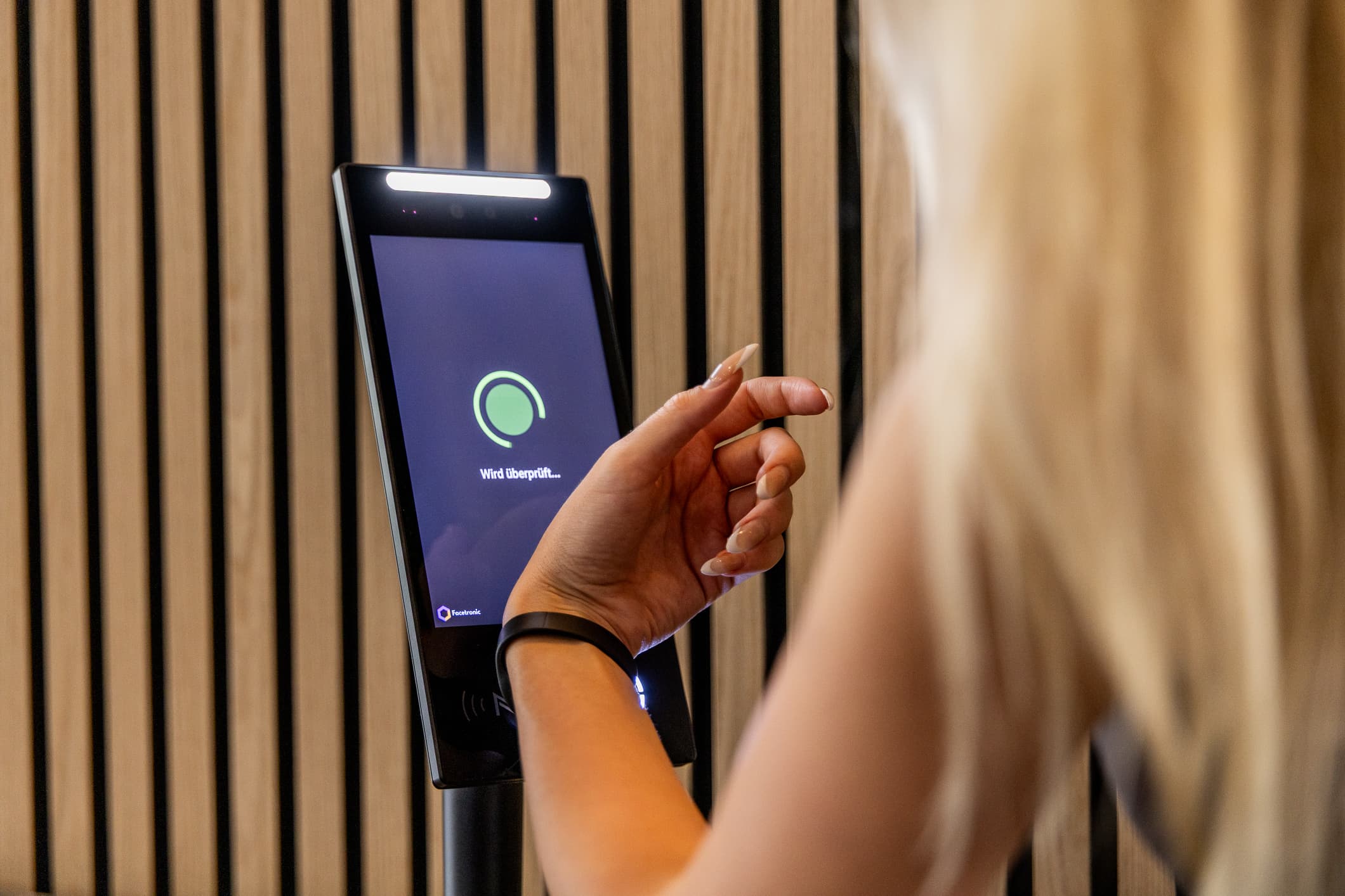 Member holding an RFID wristband to the IDA Reader as access is checked