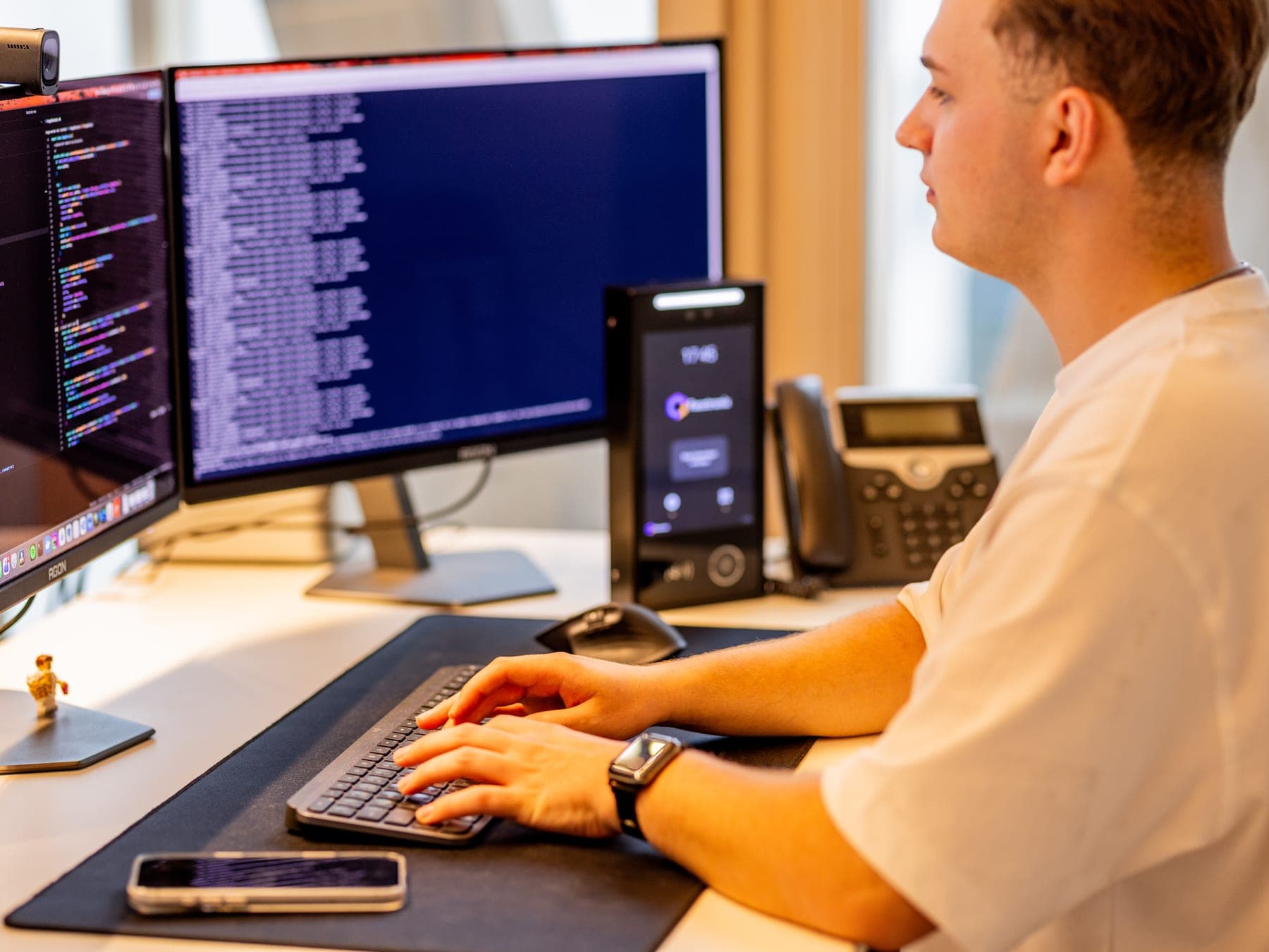 A desk at Facetronic: a developer at the keyboard, an IDA Reader beside them